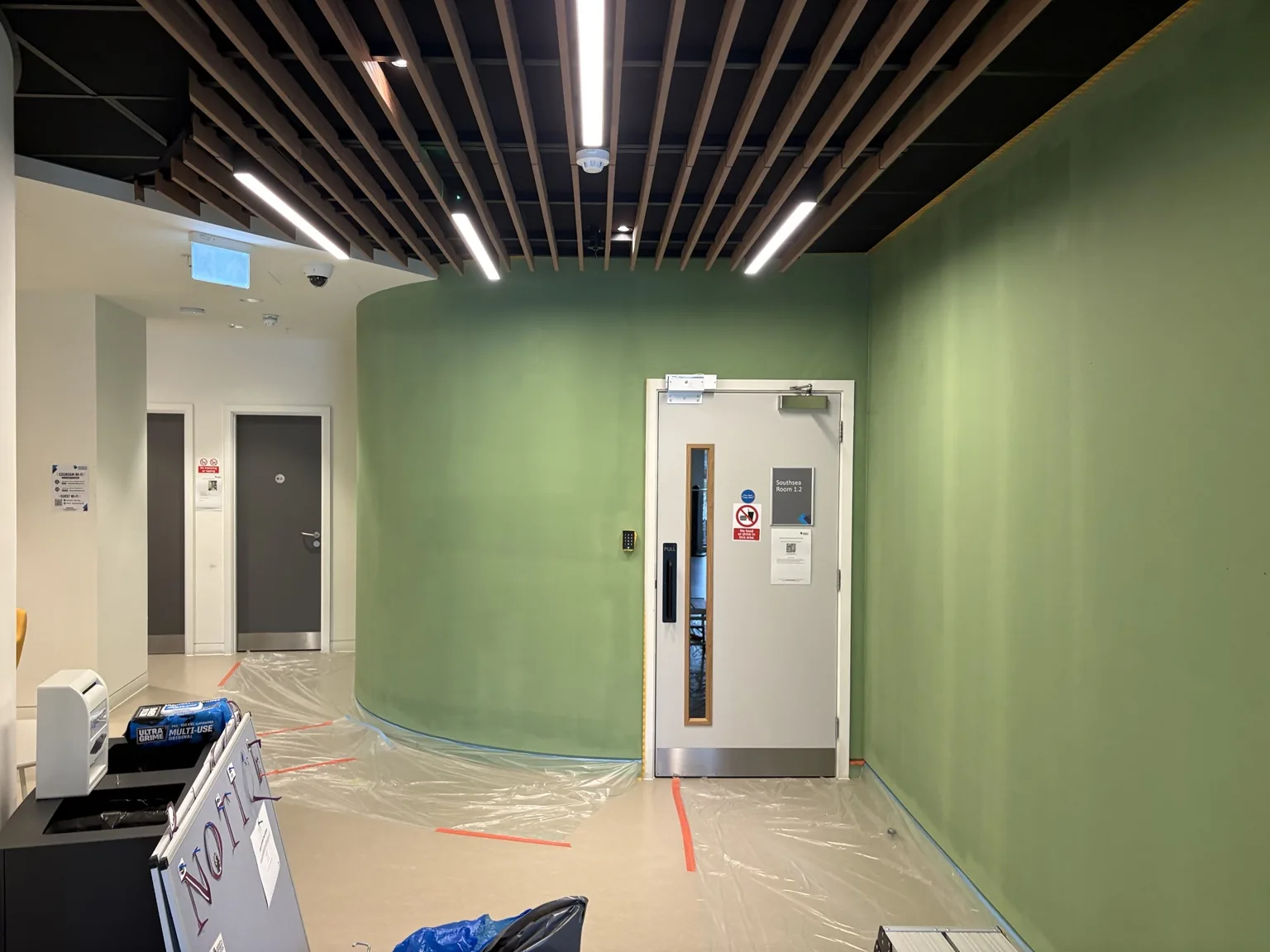 Protected commercial interior during wall preparation before painting in East London